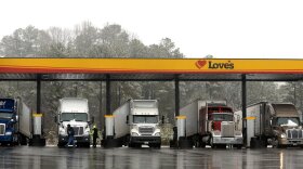 FILE - In this Feb. 11, 2014, file photo, truck drivers stop at a gas station in Emerson, Ga., north of metro Atlanta, to fill up their tractor trailer rigs. The Trump administration eased rules Thursday, May 14, 2020 that limit working hours for truck drivers, and the changes brought immediate protests from labor and safety groups. The Federal Motor Carrier Safety Administration extended the maximum working day for short-haul drivers from 12 hours to 14 hours and applied the longer hours to more drivers by expanding the geographic definition of short-haul driving. (AP Photo/David Tulis, File)