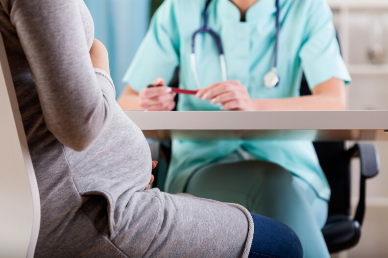 A pregnant mother meets with her doctor.
