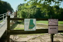 A sign on a fence in front of a river