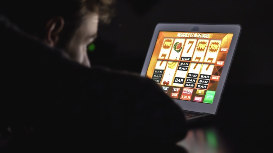 A man uses an online casino slot machine on a laptop computer in this stock image. Over 50% of calls to the Council on Compulsive Gambling of Pennsylvania's 1-800-GAMBLER hotline in 2025 specifically mentioned online gambling as the most problematic form of gambling.