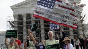 Demonstrators gather outside the Supreme Court in Washington, Tuesday, Oct. 8, 2013, as the court heard arguments on campaign finance.