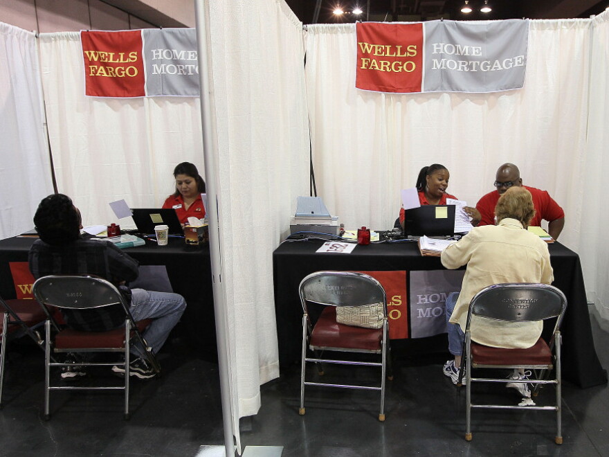 Wells Fargo employees help homeowners go over paperwork during a free workshop for customers who are facing mortgage payment challenges in Oakland, Calif.