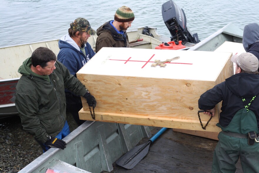 Coffins carrying Igiugig ancestors are loaded onto a skiff for the final stretch of their journey, from the Smithsonian in Washington, D.C., to a burial ground in Alaska.