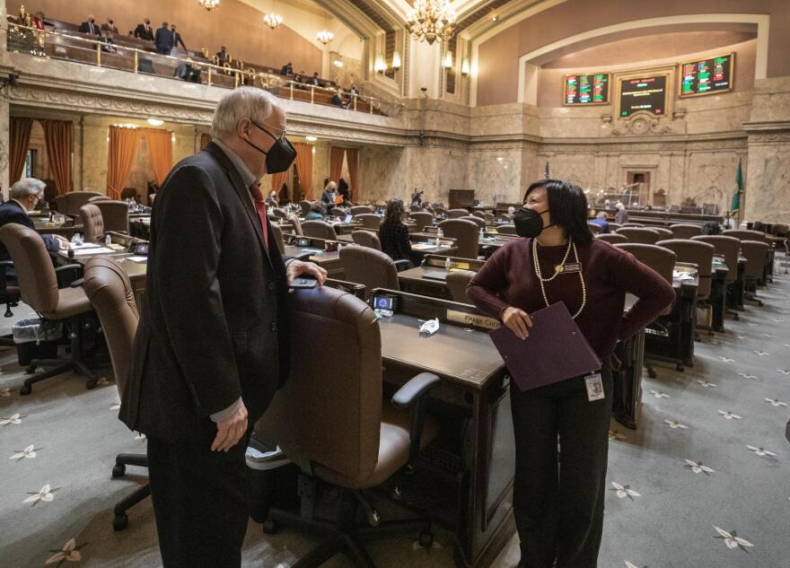 State Rep. My-Linh Thai chats with Rep. Frank Chopp during a changeover in voting on the house floor on Jan. 11, 2021, in Olympia.