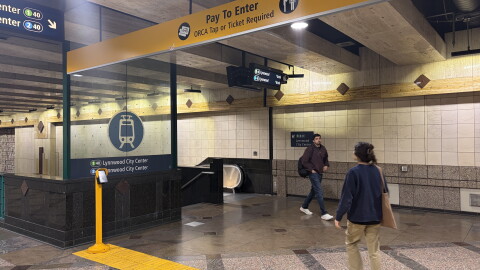 People walk to the escalator at the entrance to the Westlake Light Rail Station. 