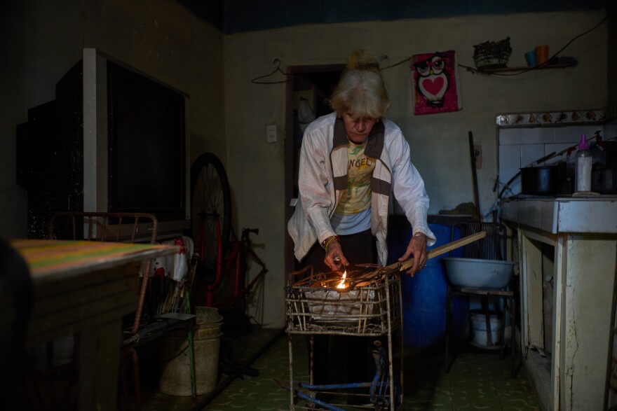 Minorkys Hoyos Ruiz lights coals to cook dinner during a scheduled blackout to ration energy in Santa Cruz del Norte, home to one of Cuba’s largest thermoelectric plants, on Feb. 3, 2026.