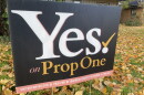 A close up of a political yard sign promoting the prop 1 ballot initiative, on a lawn strewn with fall leaves