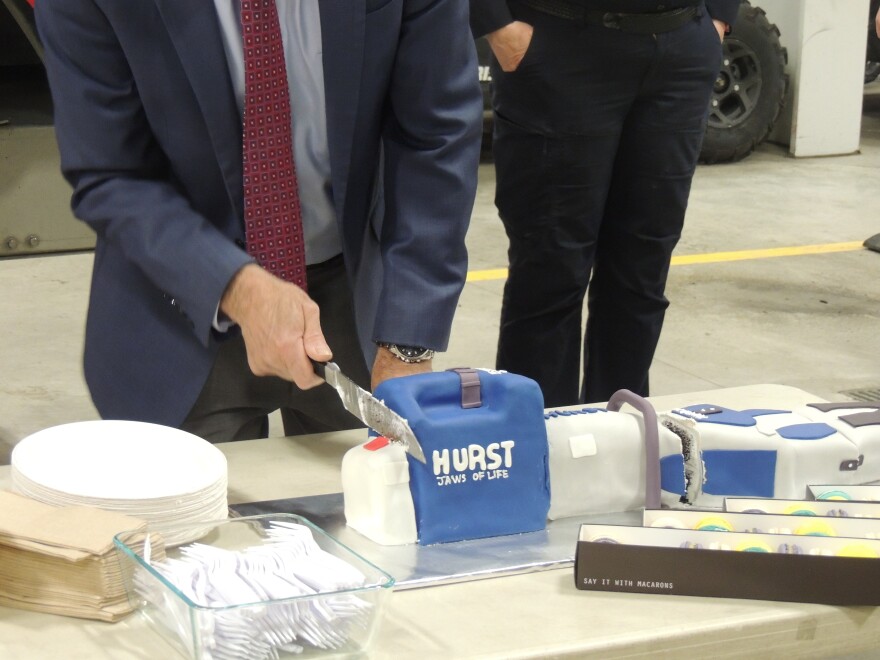 Mayor Micciche cuts into the jaws of life replica cake.