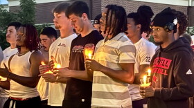 William Jewell football players hold candles during the vigil for MichaJo Barnett.