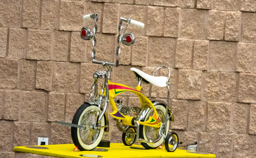 Small yellow tricycle on a stand, photo by Alexander Brown.