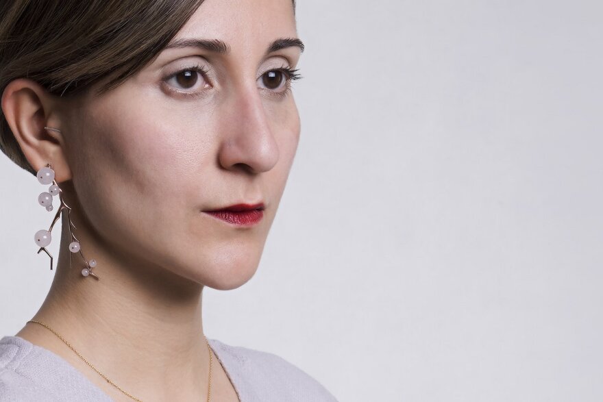 A woman with red lipstick looks across the camera view. Behind is a solid grey background.
