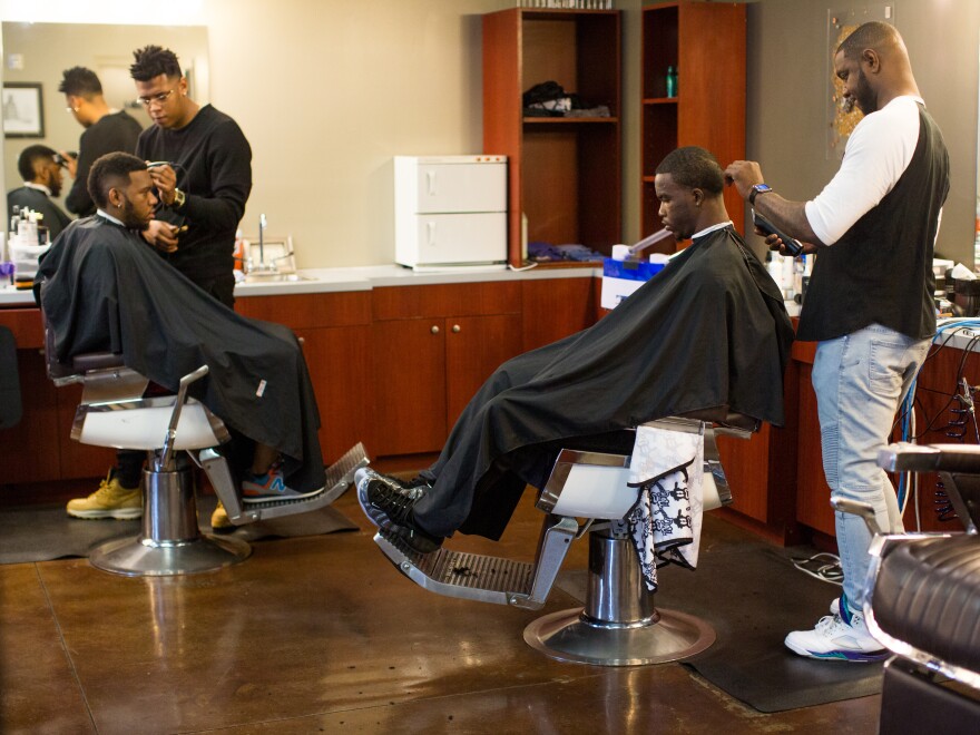 Customers get haircuts on a busy Saturday morning at No Grease Mosaic Village in Charlotte, N.C.