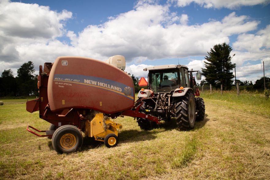 Fourth-generation soybean farmer Bob Thompson drives his tractor and hay baler through his field in Weidman Michigan, on June 22, 2026. The president of the Michigan Farmers Union said most farmers have bought used equipment in recent years.