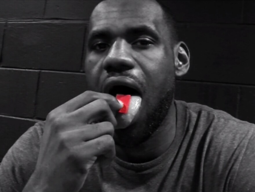 In a screen shot from a promotional video for a new energy product, NBA star LeBron James places a bright red gel strip on his tongue.