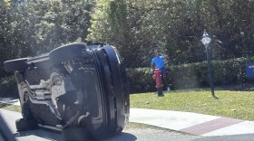 Golfer Tiger Woods stands by his overturned vehicle in Jupiter Island, Fla., on Friday, March 27, 2026.