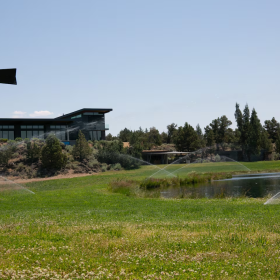 Sprinklers keep the grass green in the landscaping surrounding a pond and a pool at a property in Central Oregon