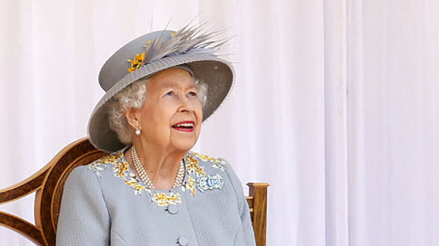 FILE - Britain's Queen Elizabeth II watches the red arrows fly over to mark her official birthday at Windsor Castle, Windsor, England, Saturday June 12, 2021.