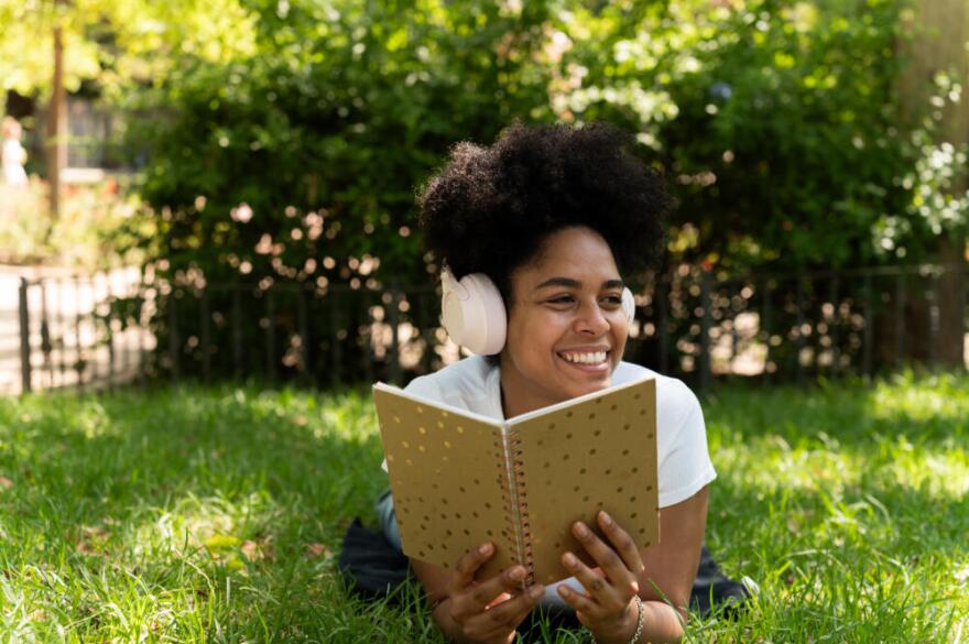 A woman listens to an audiobook with headphones. (Getty Images)