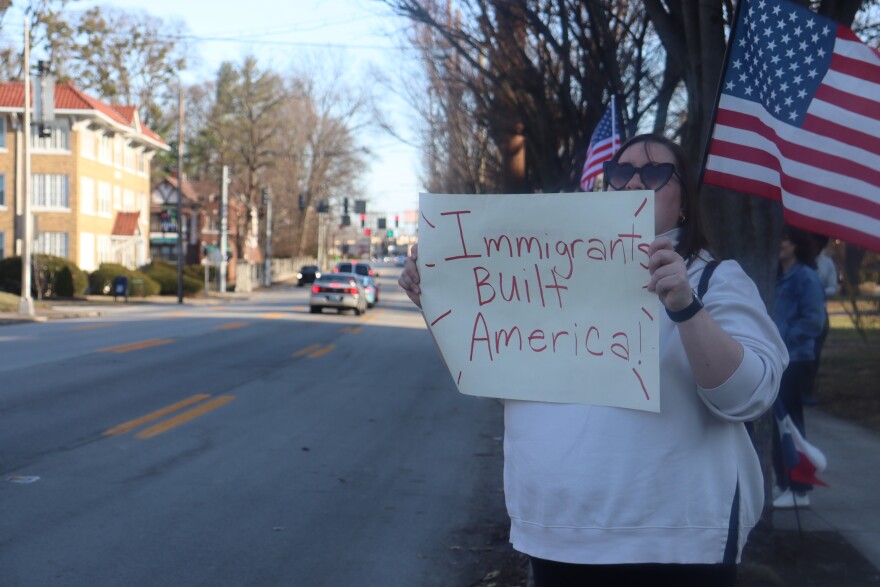 A woman holding a sign that reads "Immigrants built America!" on Bardstown Road