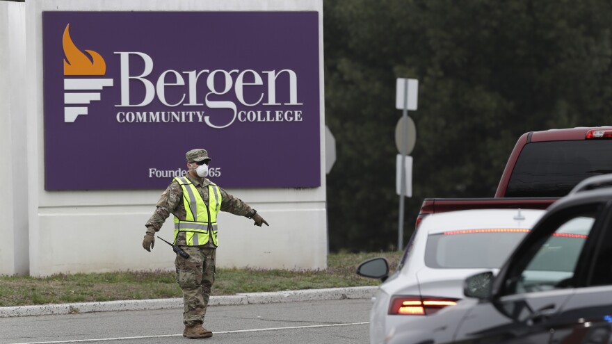 A member of the New Jersey National Guard directs traffic at the entrance to a drive-thru COVID-19 testing center in Paramus, N.J., on March 20, 2020.