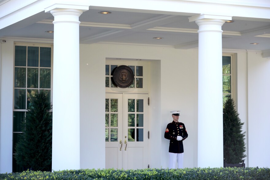 A U.S. Marine stands watch Wednesday outside the doors of the White House West Wing. According to the White House, President Trump was in the Oval Office on Wednesday afternoon, even as he continues to be monitored for COVID-19.