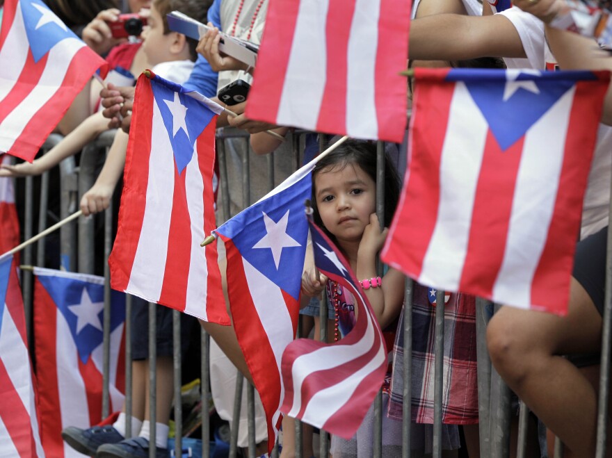 People wave Puerto Rican flags at the National Puerto Rican Day parade last year.