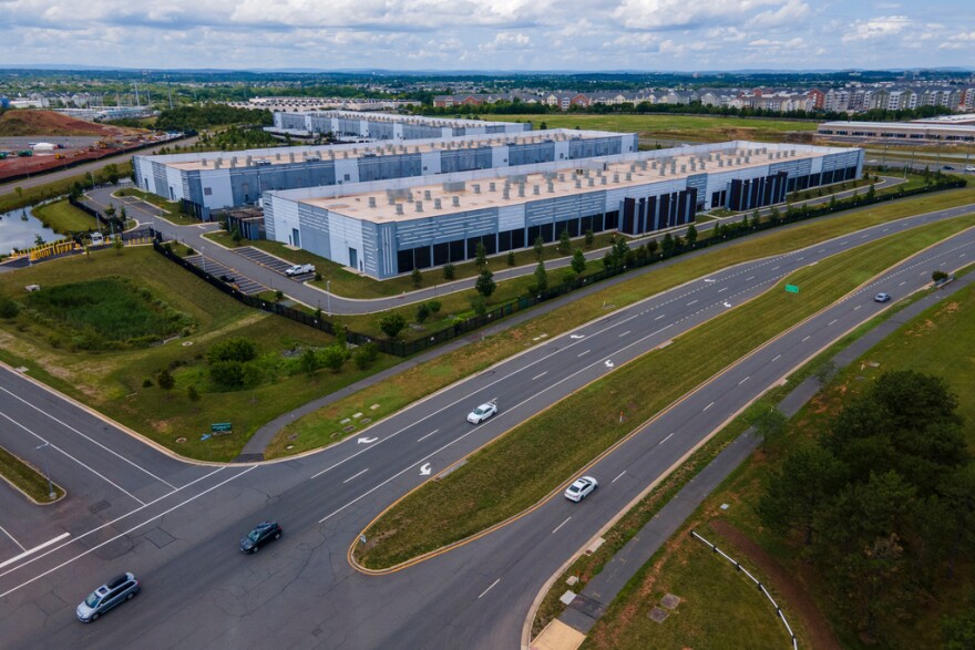 FILE - Cars drive past data centers that house computer servers and hardware required to support modern internet use, such as artificial intelligence, in Ashburn, Virginia, July 16, 2023.