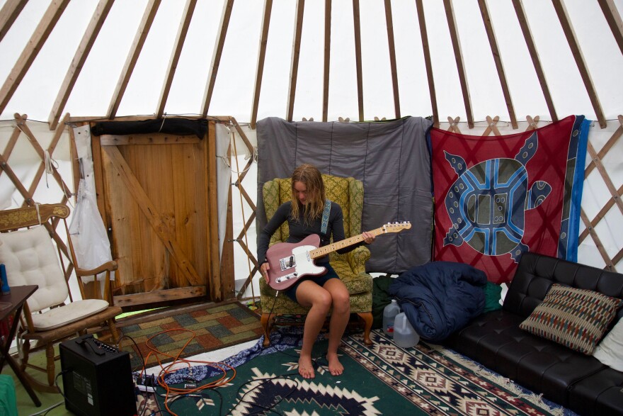 A young woman with a guitar.