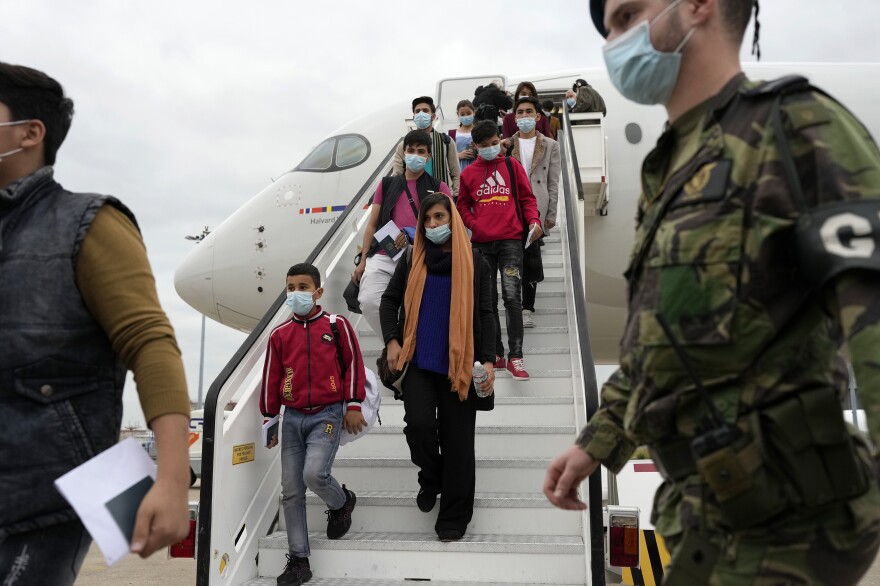 Afghan music students, teachers and their families disembark from their flight to Lisbon on Dec. 13. The group of more than 270 evacuees had been staying in Doha, awaiting resettlement in Portugal.