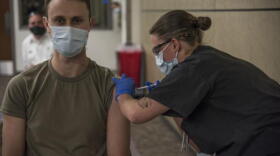 Airman 1st Class Kimber Bernau, 59th Medical Wing Family Emergency Clinic medical technician, administers the San Antonio Military Health System’s first Pfizer COVID-19 vaccine shot to Maj. Andrew Gausepohl, Dec. 14, 2020, at Wilford Hall Ambulatory Surgical Center, Joint Base San Antonio-Lackland, Texas.