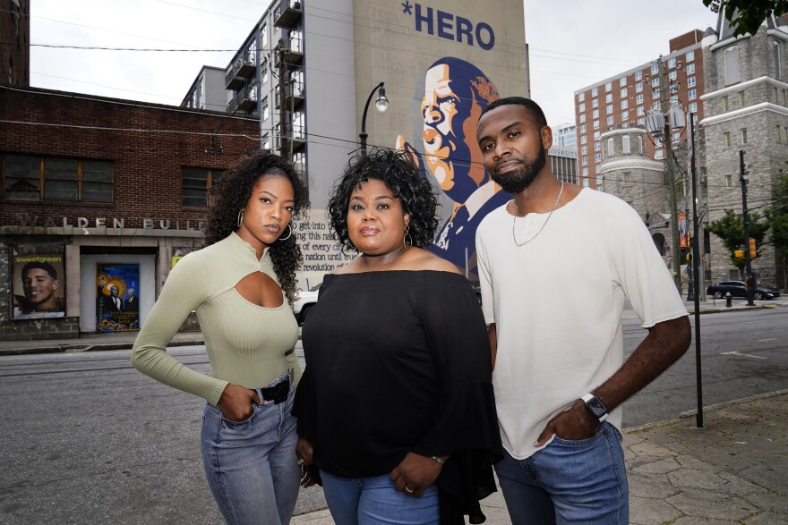 D'Zhane Parker, left, Cicley Gay, center, and Shalomyah Bowers pose for a portrait on Friday, May 13, 2022, in Atlanta. They are the three members the of Black Lives Matter Global Network Foundation Inc. board of directors. (AP Photo/Brynn Anderson)