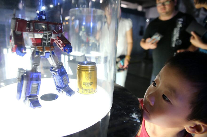 A boy looks at a toy model of Transformers character Optimus Prime on display at a Transformers Model Show in Qingdao city in northeast China.