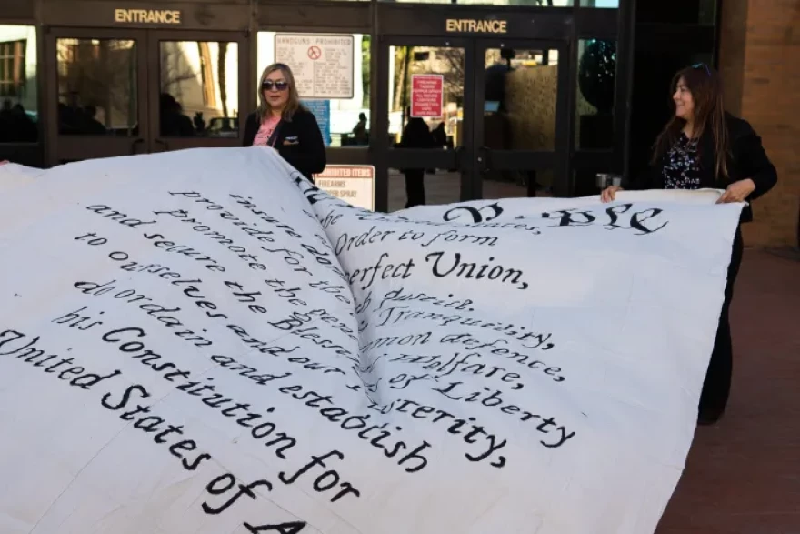 Protesters unfurl a large sheet painted with the preamble to the constitution during a press conference of religious and civil leaders who sought to encourage the El Paso community in the face of escalating ICE raids, Jan. 16, 2026.
