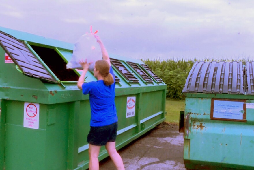 Amy Rather drops recycling into one of the bins behind the Johnson County Recycling District office. After July 31, this bin won't be available.