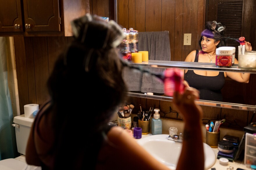 Amy Taylor does her hair in her Hyde Park apartment Monday. She says she has struggled ever since her rent went up $165. She now also owes fees for pest control and trash collection.