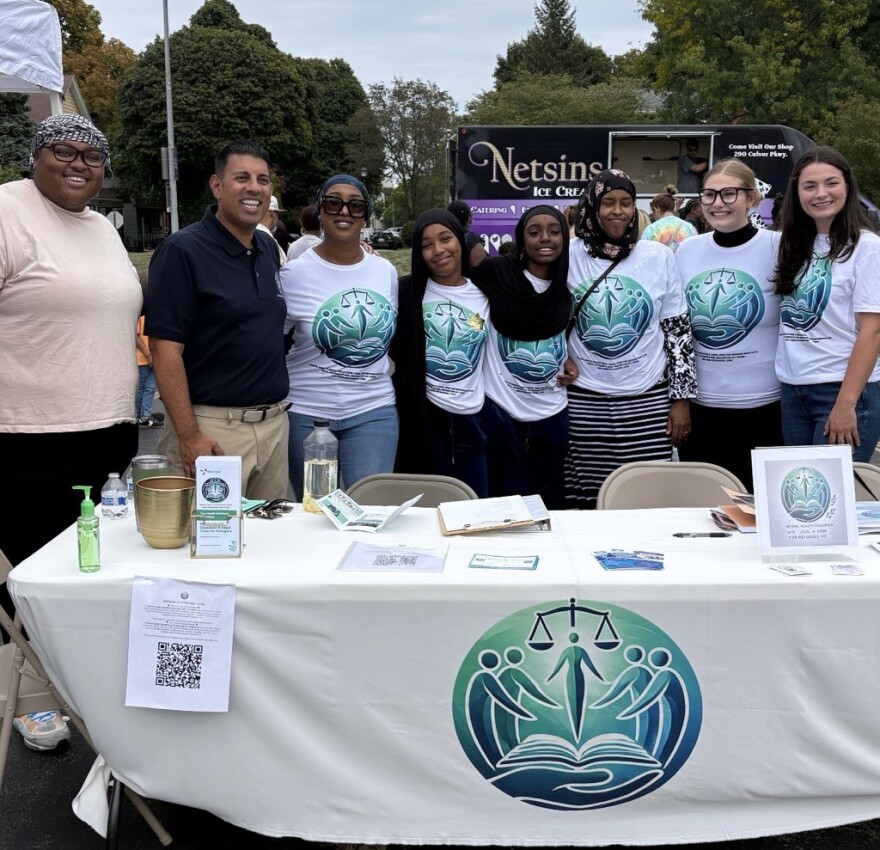 The Team at Mental Health Education and Legal Code for Refugees, Inc. stand with state Sen. Jeremy Cooney while doing outreach work.