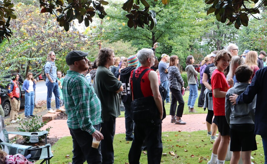 A crowd of attendees watch artists play music at porchfest