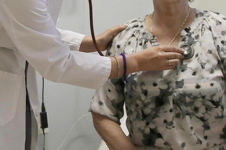 A doctor examines a patient at a clinic in Stanford, California. (Jeff Chiu/AP)