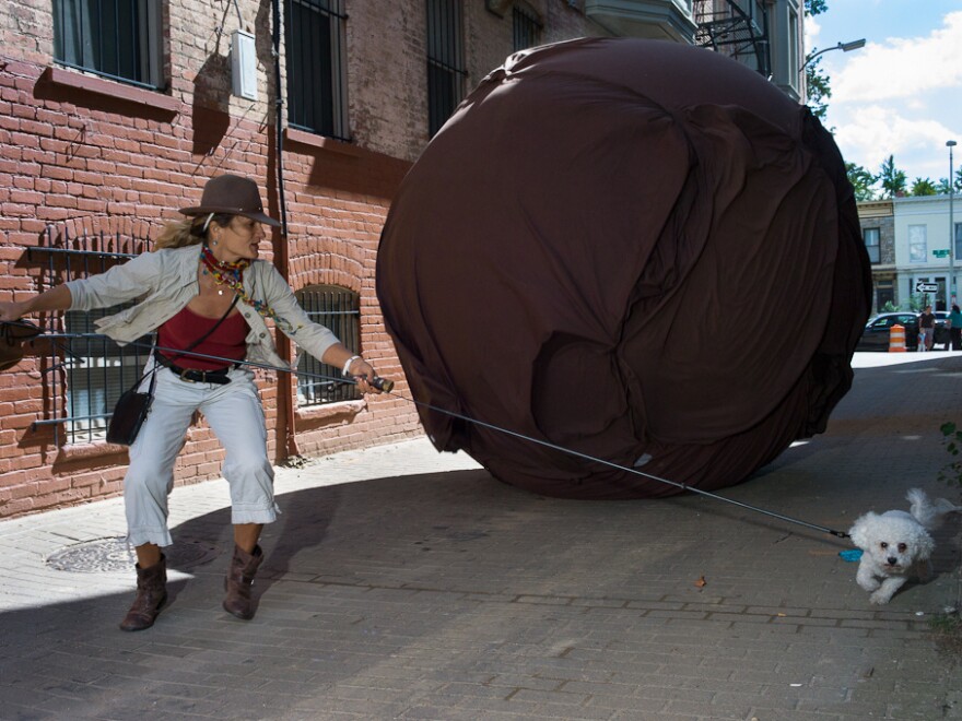 Janet Whitley borrows a stranger's dog to run away from a 10-foot-high plastic boulder in Washington, D.C.'s "Alley of Doom."