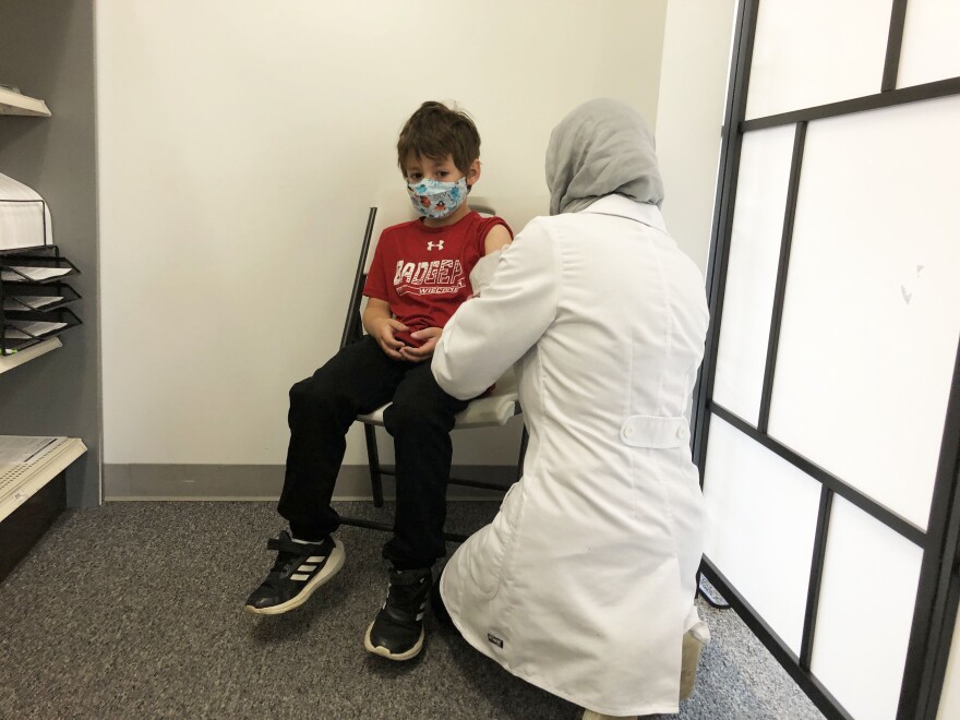 Marwa Bakr administers a COVID vaccination for 6-year-old Daniel Salinas.