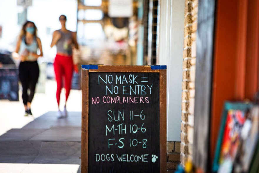  A sign on South Congress Avenue in Austin lists masking requirements.