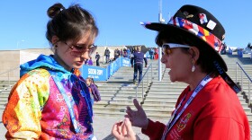 International Sports Chaplain Myrna Gregory (right) uses a souvenir pin to tell a gospel story to a Russian volunteer at the Sochi Olympic Park.
