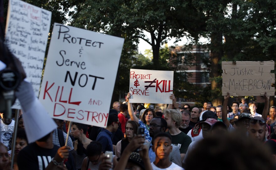 Protestors hold signs in support of those in Ferguson, Mo., during a rally at Meridian Hill Park, also known as Malcolm X Park, in Washington.