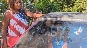 Wanda Royal Torres brushes her hand across the roof of her husband's car to show the fine, black soot that settles on her neighborhood from U.S. Steel Gary Works across the street.