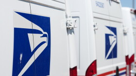 FILE - Delivery vans are parked during a protest staged as part of a countrywide National Day of Action Tuesday, July 28, 2026, outside the main United States Postal Service headquarters in northeast Denver.