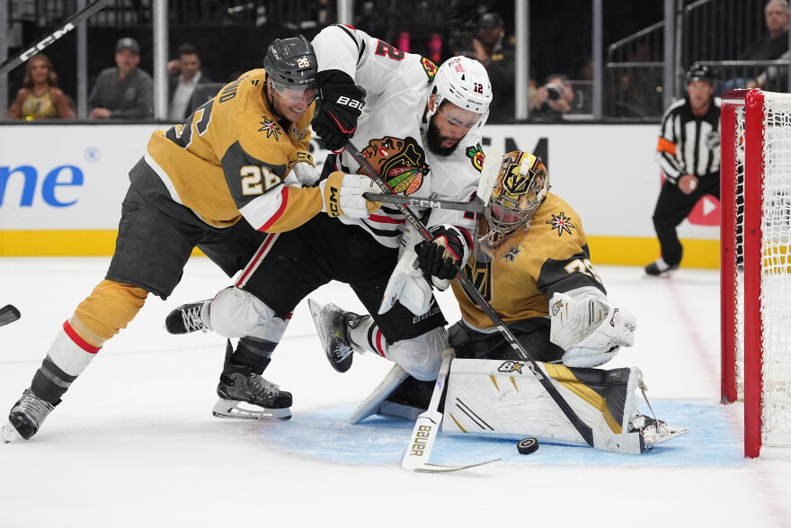 Chicago Blackhawks' Jordan Greenway (12) falls into Vegas Golden Knights goaltender Carter Hart (79) during the first period of an NHL hockey game Tuesday, Sept. 29, 2026, in Las Vegas. (AP Photo/John Locher)