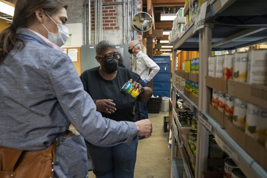 Helena Smith, center, of Washington, chooses a food item while shopping at Bread for the City, Wednesday, May 10, 2023, a food pantry in Washington. The formal end of the national Public Health Emergency on Thursday marks the end of several U.S. pandemic-era emergency support program, from extra food assistance to automatic enrollment in Medicaid. "I like this a lot because they give us a variety of fruit," says Smith, "instead of just cans."