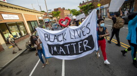 Protesters begin their march down Centre Street towards the Boston Police E-13 District station in Jamaica Plain. (Jesse Costa/WBUR)