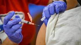 Registered Nurse Raquel Garcia, a Truman Medical Centers employee, injects James Watts, 71, with the Pfizer BioNTech COVID-19 vaccine at Linwood YMCA on Feb. 3.