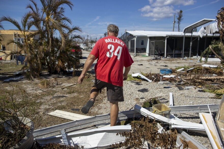 John Orbanus walks through rubble in the backyard of his home in the Flamingo Bay neighborhood of Pine Island.